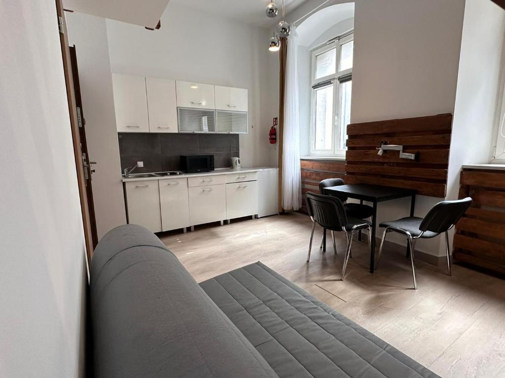 salon z kanapą, stołem i krzesłami w obiekcie Apartamenty Gołębia-Genius w Poznaniu
