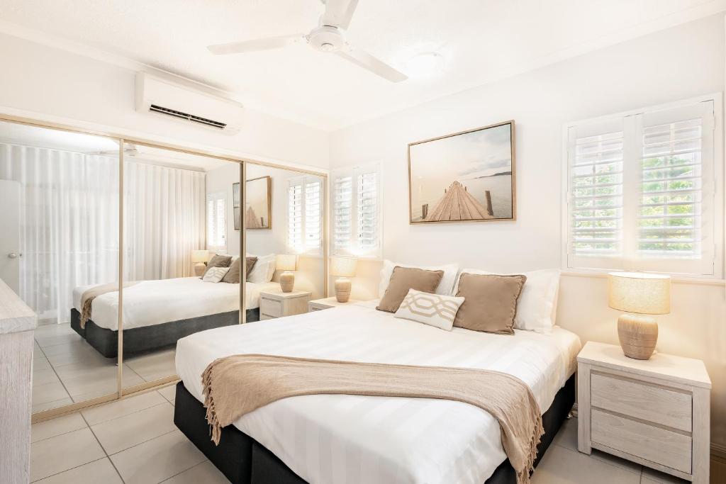 una camera bianca con due letti di Cairns 2BR Resort Escape, 4 Pools 5 min to Airport a Cairns North
