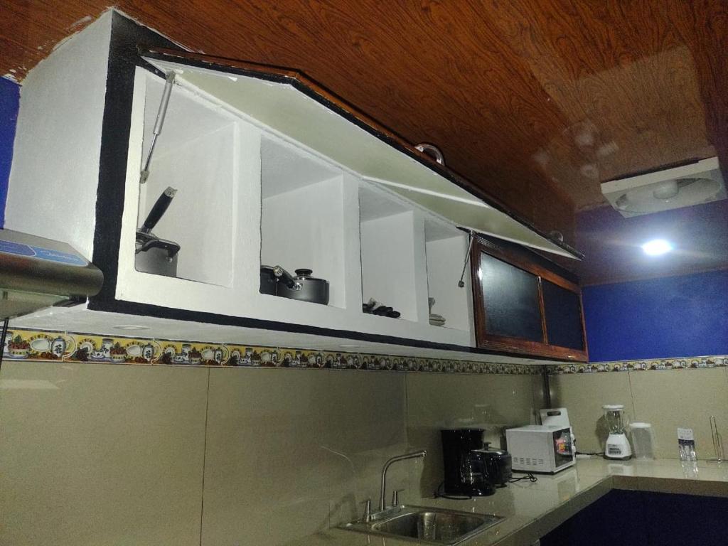 a kitchen with a sink with a window above it at Cabinas Pacifico in Puntarenas