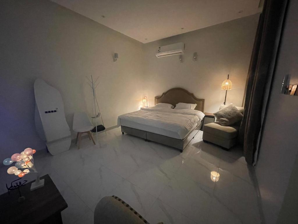 a bedroom with a bed and a chair in it at Al Jadeed Istudio In Al Jubaylah in Al ‘Uyaynah