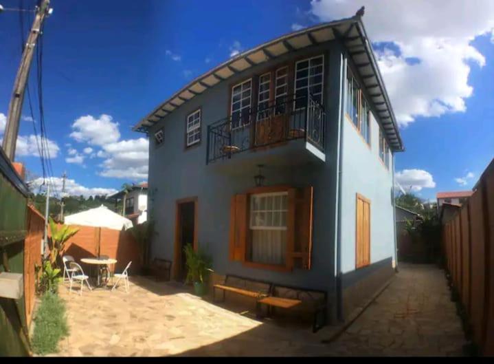 una casa azul y blanca con un banco delante en Pouso Casazul en Tiradentes