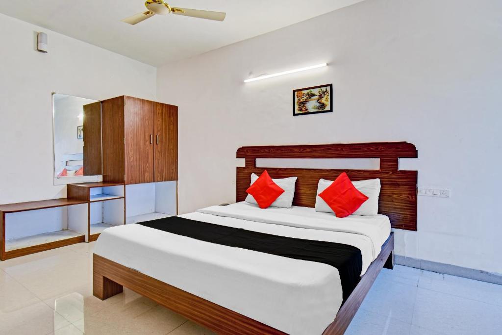 ein Schlafzimmer mit einem großen Bett mit roten Kissen in der Unterkunft Collection O Iris in Chikalthān