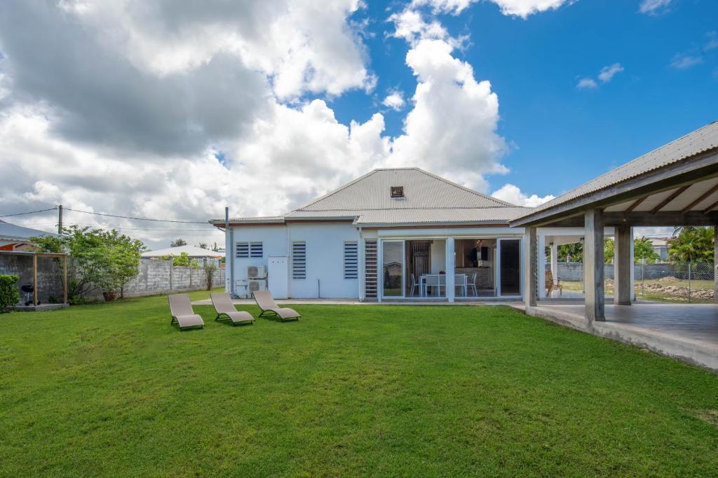 einen Hof mit zwei Liegestühlen und einem Haus in der Unterkunft La villa de Lynko in Le Moule