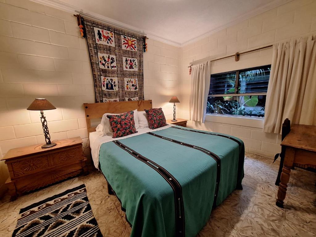 Un dormitorio con una cama grande y una ventana en Yellow House Hostel B&B en Antigua Guatemala