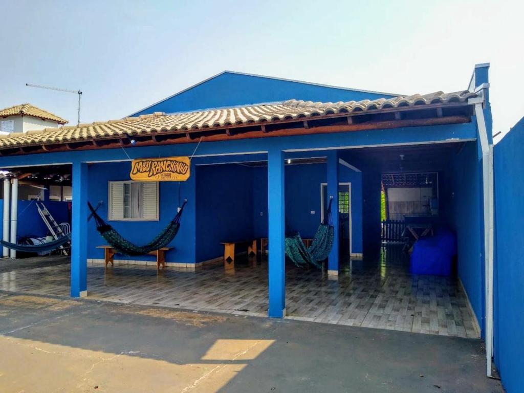 a blue building with hammocks on the side of it at Meu Ranchinho in Presidente Epitácio