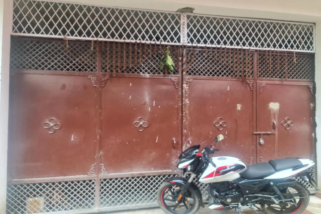 a motorcycle parked in front of a garage door at SPOT ON Aaditya Hotel in Patna