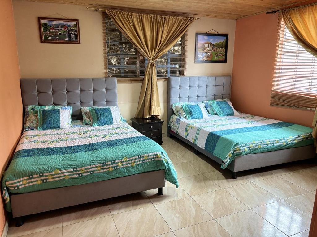 a bedroom with two beds and a window at Hospedaje Rural Villa Sadais in Monguí