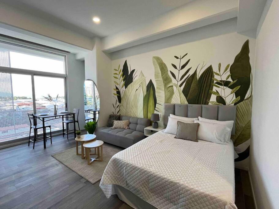 a bedroom with a bed with a large mural of leaves at Sersua - Nature in the City in Guatemala