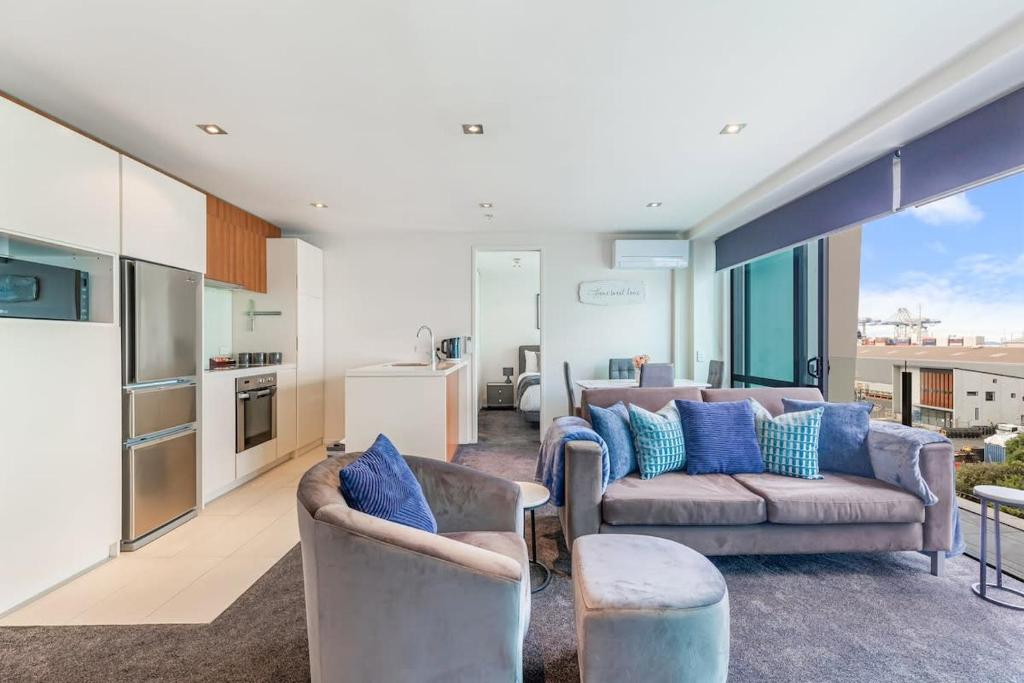 ein Wohnzimmer mit 2 Sofas und einer Küche in der Unterkunft Serene 2Bed Gem with Free Parking in Auckland