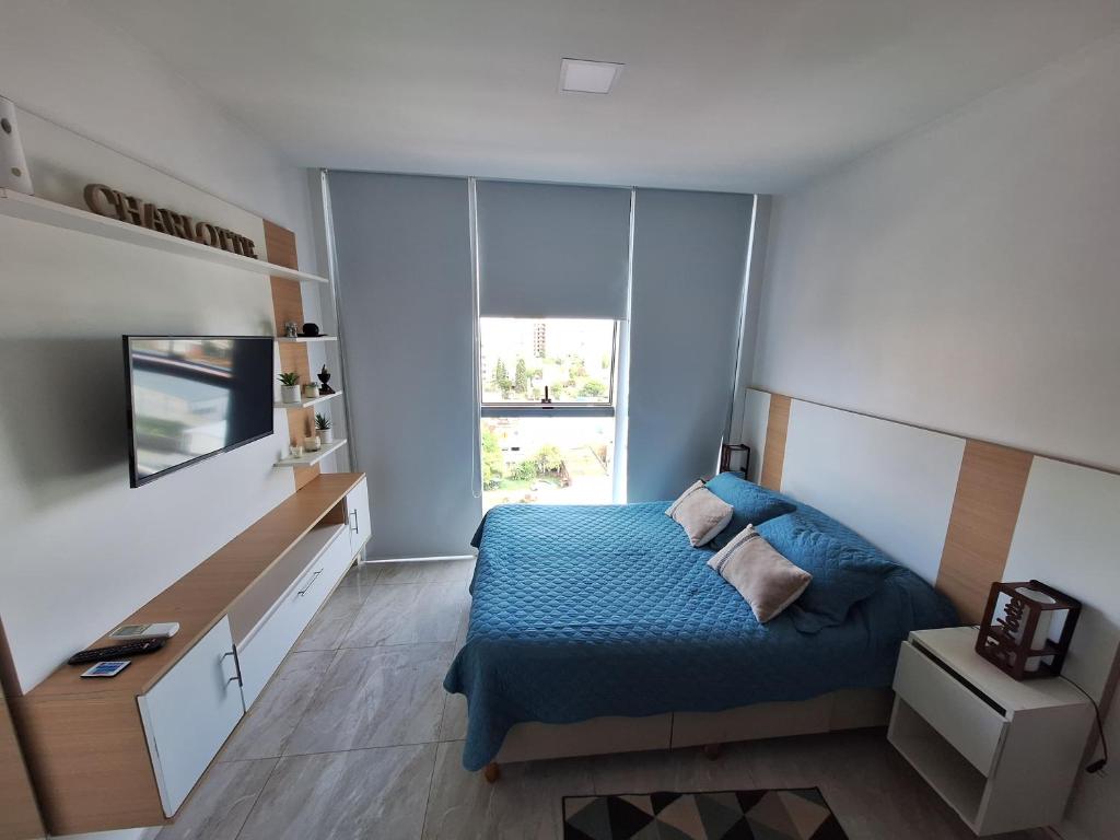 a small bedroom with a blue bed and a desk at Edificio Charlotte (zona centro) in Posadas