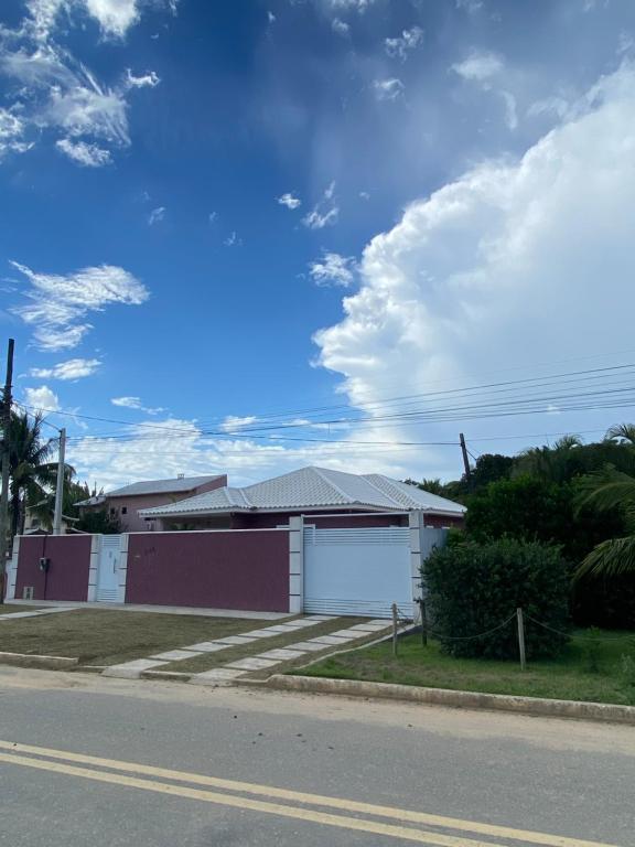 una casa al lado de una calle con un cielo en Casa Recanto da Praia Itaúna, en Saquarema
