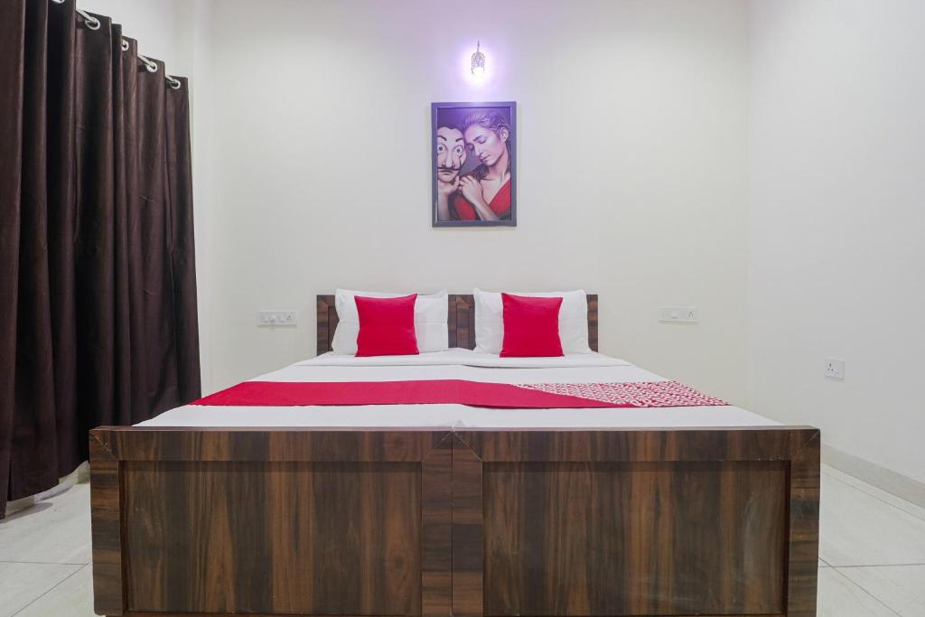 een slaapkamer met een groot bed met rode kussens bij OYO Hotel Bella Ciao in Ludhiana