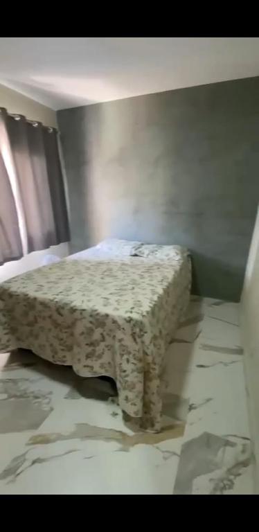 a bedroom with a bed with a table in it at Edifício Ceres in Guarapari