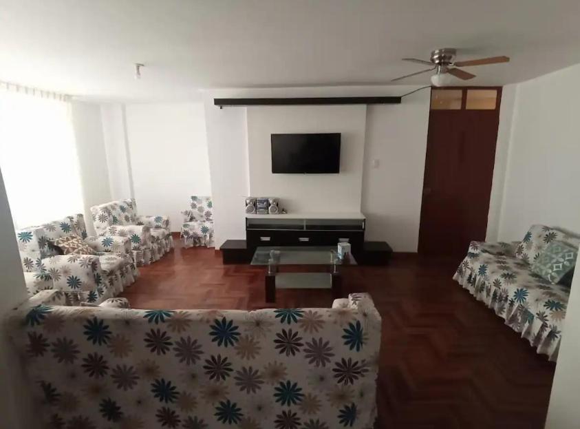 een woonkamer met banken en een flatscreen-tv bij Siéntete como en casa in Ilo