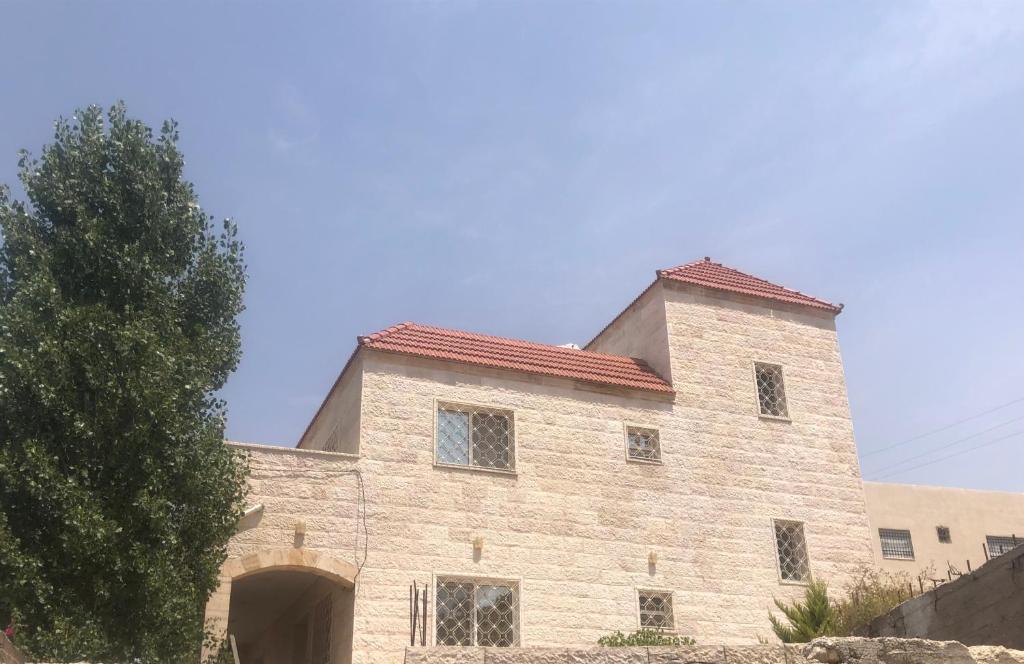 an old stone building with a red roof at عجلون Ajloun in Ajloun