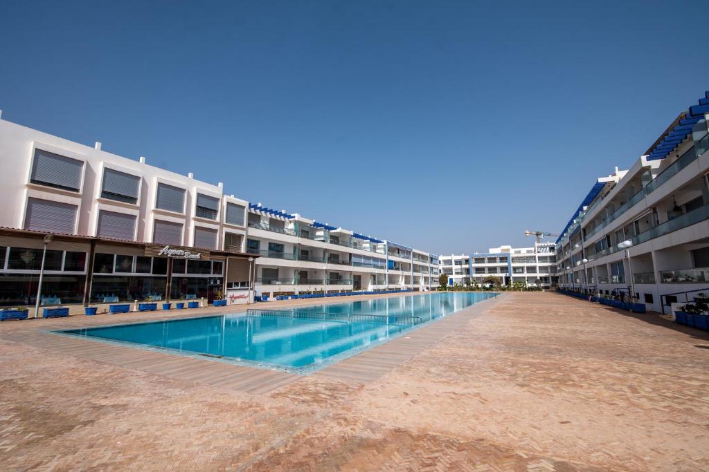 - une piscine vide dans un immeuble d'appartements dans l'établissement Appartement en bord de mer avec piscine, à Aourir