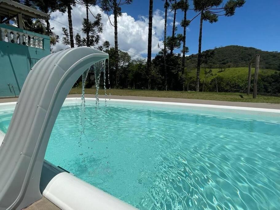 - un toboggan en plastique dans la piscine dans l'établissement Recanto do sossego, à São Bento do Sapucaí