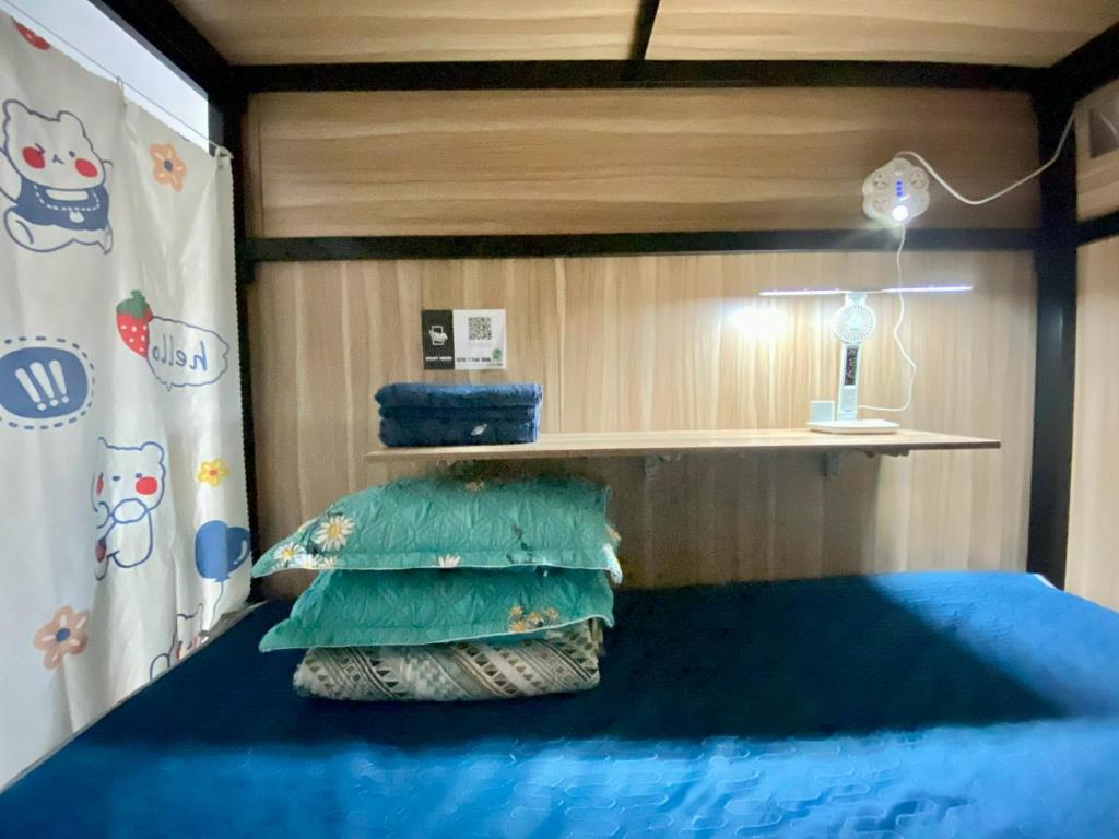 una camera da letto con letto con lenzuola e cuscini blu di Start House CAPSULE 5 min walk to the Airport ad Ho Chi Minh