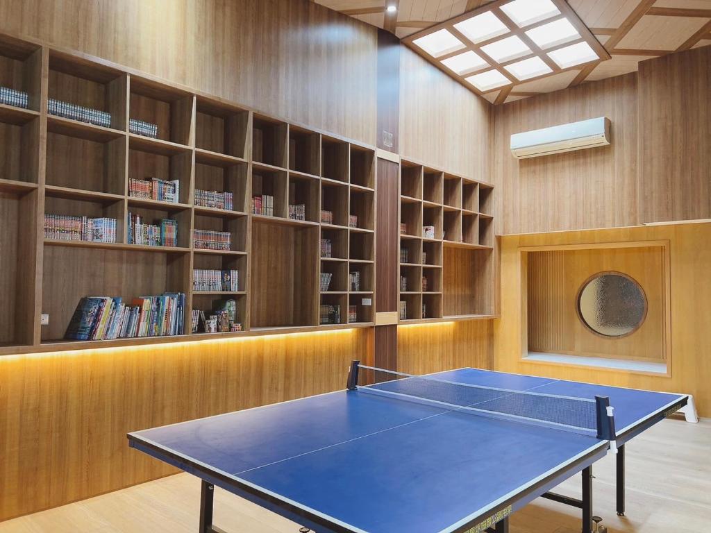 ein Zimmer mit einer Tischtennisplatte in einer Bibliothek in der Unterkunft Triple One Entire Home 慶東111私人招待所 包棟民宿 in Tainan