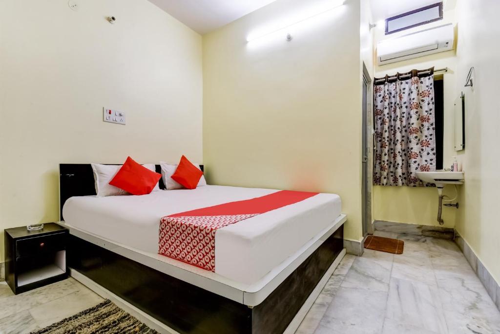a bedroom with a large white bed with red pillows at Hotel Basera in Bankipur