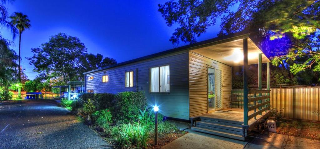 a small wooden house with lights on it at Highway Tourist Village in Narrabri