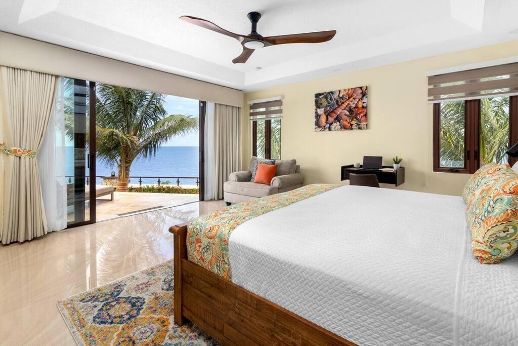 a bedroom with a bed and a view of the ocean at Oceanfront Luxe Villa In St Mary Fully Staffed in St Mary