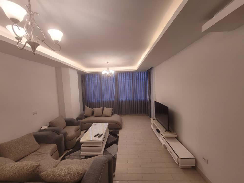 a living room with couches and a flat screen tv at Alsam Real Estate Gust House in Addis Ababa