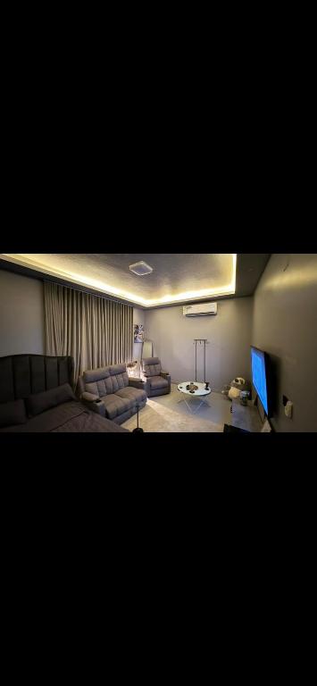 a living room with a couch and a television at شقة استديو حي المغرزات in Riyadh