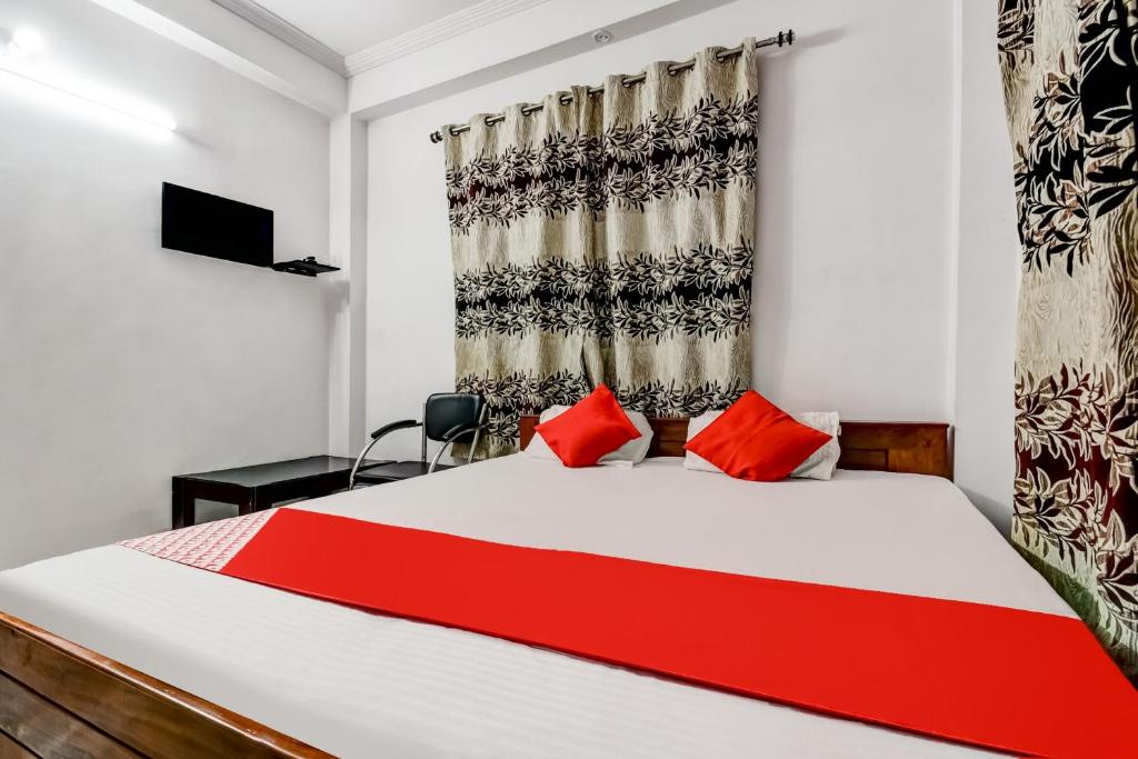 um quarto com uma cama com almofadas vermelhas e uma janela em OYO Flagship Hotel Capital Hill em Rajgir