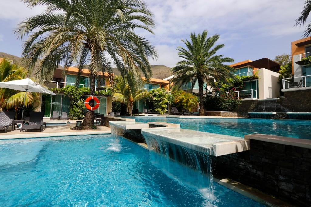 a swimming pool with a waterfall in a resort at Hotel Boutique Maloka in Flandes