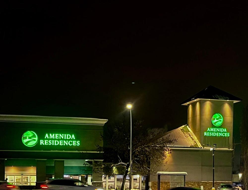 a building with aania reserves sign on it at night at Amenida Residences, Calgary in Calgary