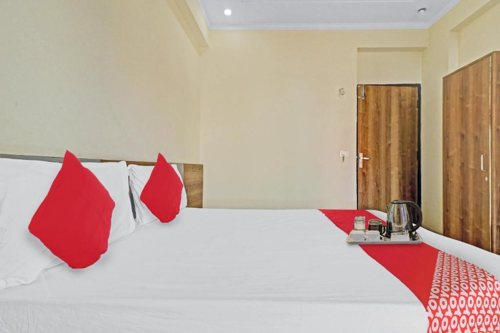 a bedroom with a large bed with red pillows at OYO Star Residency Near Omaxe Gurgaon Mall in Gurgaon