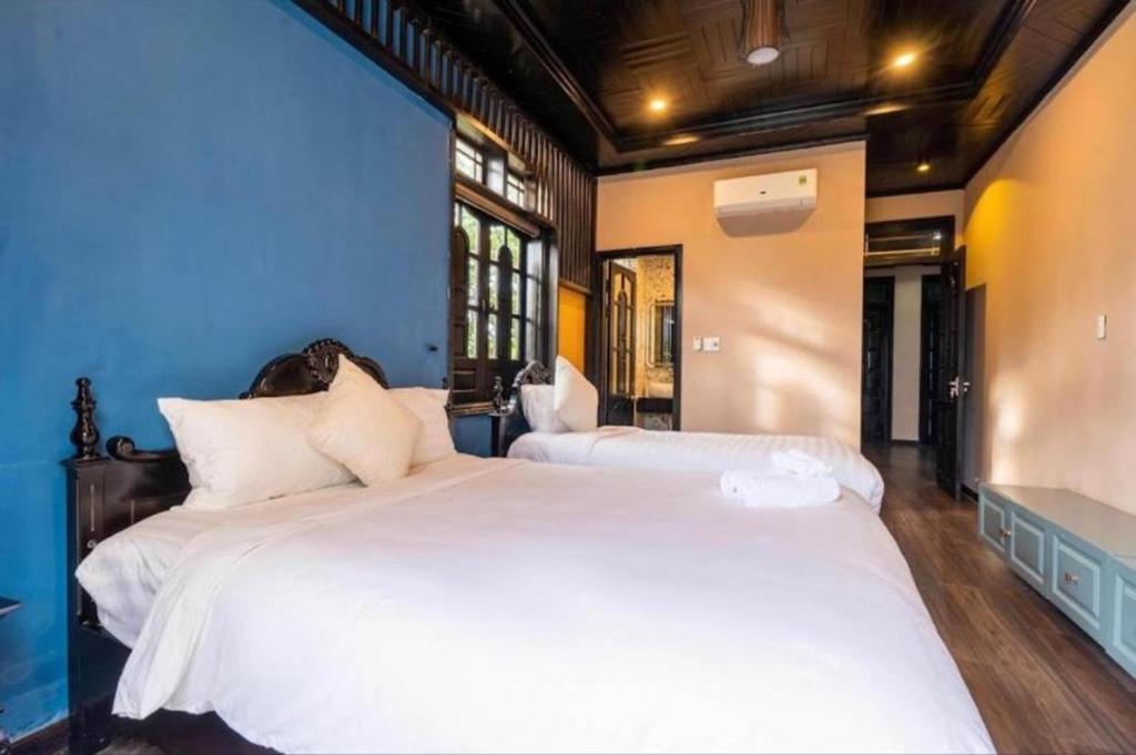 1 Schlafzimmer mit 2 Betten und weißer Bettwäsche in der Unterkunft New Luxury villa - Venuestay in Hà My Tây (2)