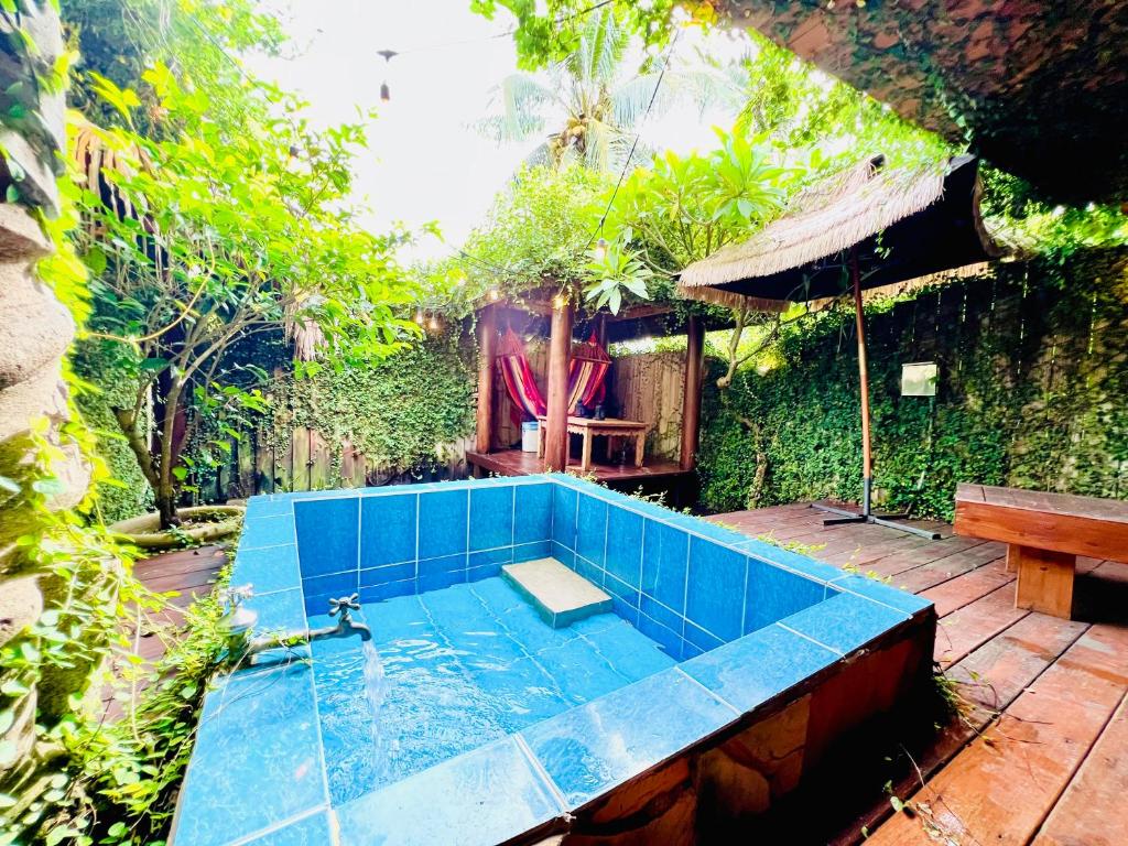 a small swimming pool in a garden with a bench at Kenting Afei Surf Hostel Nanwan in Nanwan