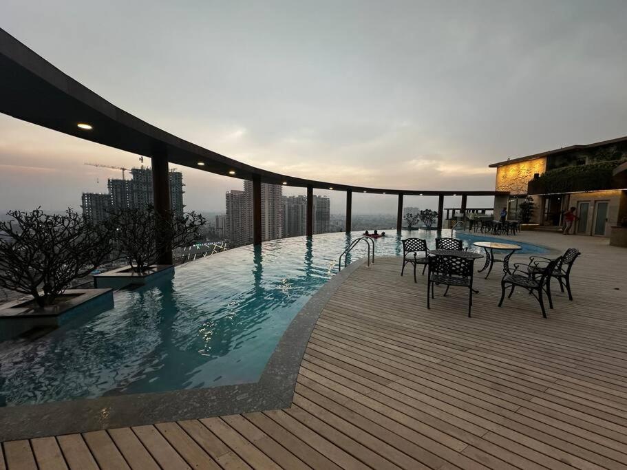 a swimming pool on top of a building with tables and chairs at 3-BHK with pool & highway view. in Ghaziabad