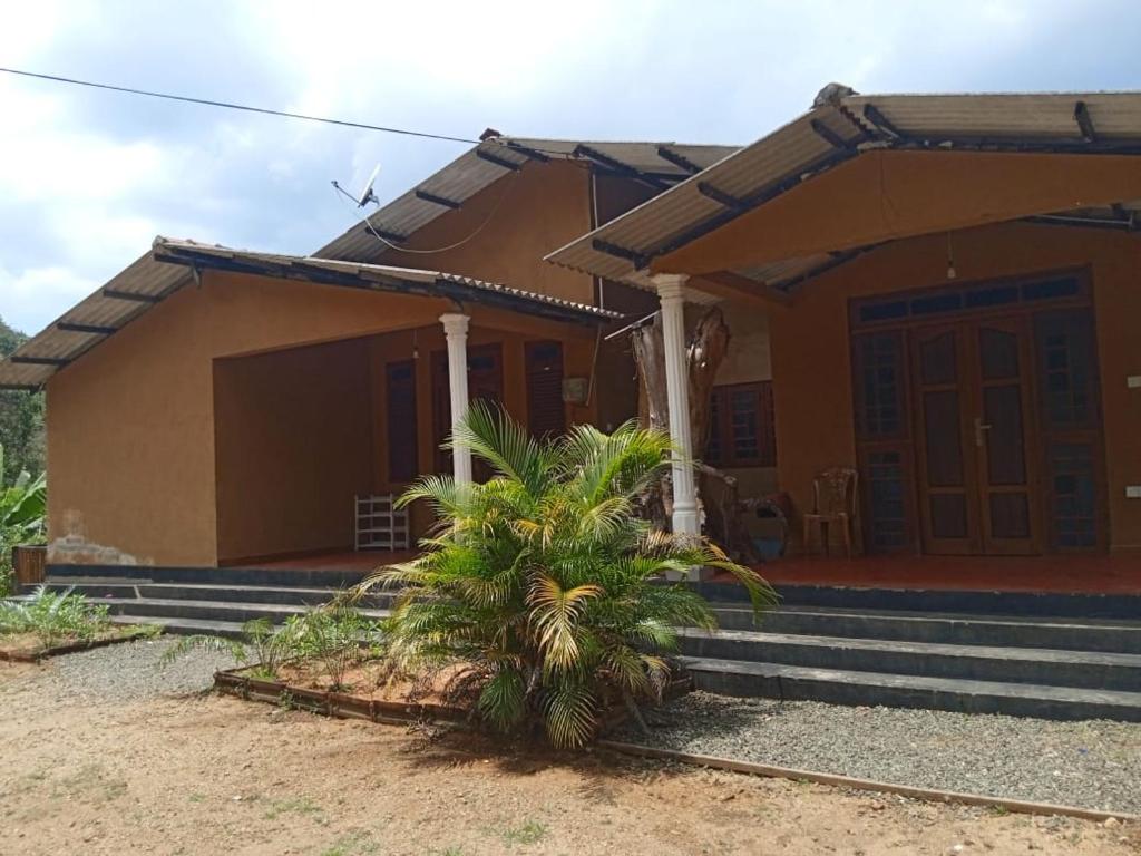 une petite maison avec un palmier en face dans l'établissement RS Holiday Residence, à Ilukkumbura