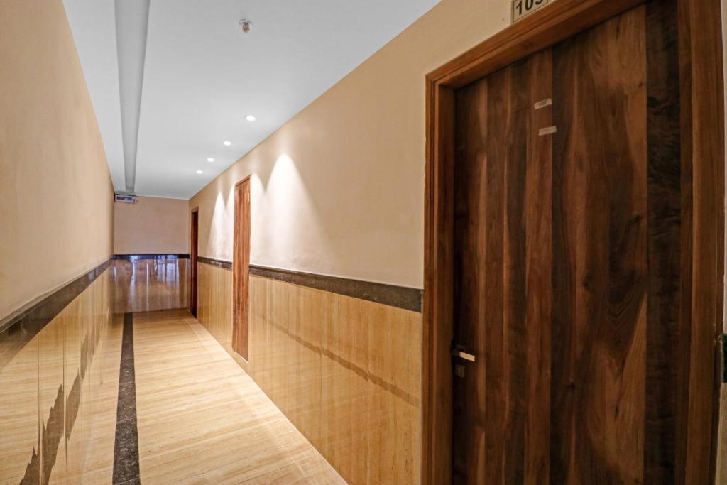 un couloir avec une porte en bois dans un bâtiment dans l'établissement Collection O Hotel Moon, à Jammu