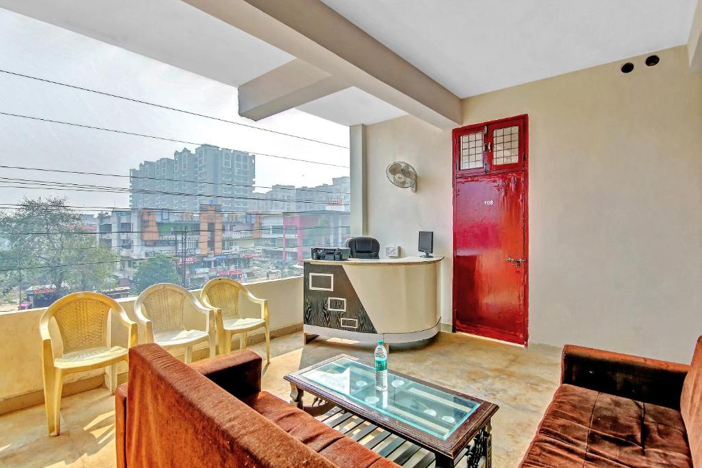 sala de estar con puerta roja y ventana en OYO Yash Hotel, en Ghaziabad