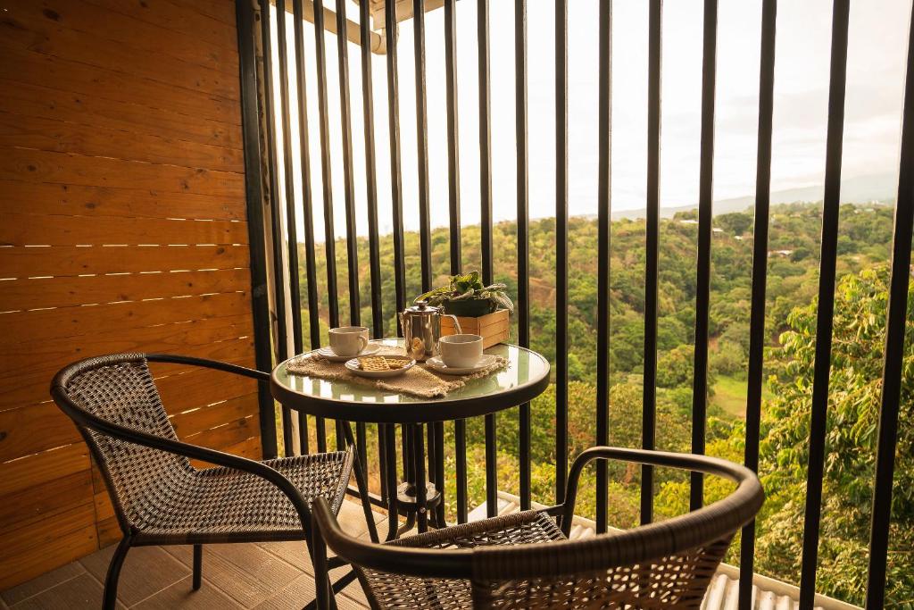 einen Tisch und zwei Stühle auf einem Balkon mit Aussicht in der Unterkunft Victoria´s House in Grecia