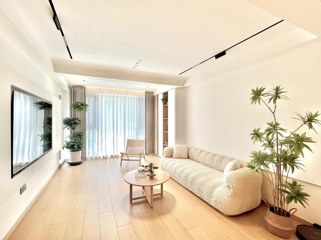 uma sala de estar com um sofá e uma mesa em Pikkie Designer's Stylish Three Bed Room Apartmemt em Zhangjiajie