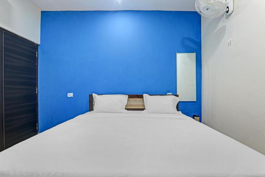 a blue bedroom with a large bed with white pillows at OYO Hotel Rudra Palace Near Phoenix United Lucknow in Charbagh