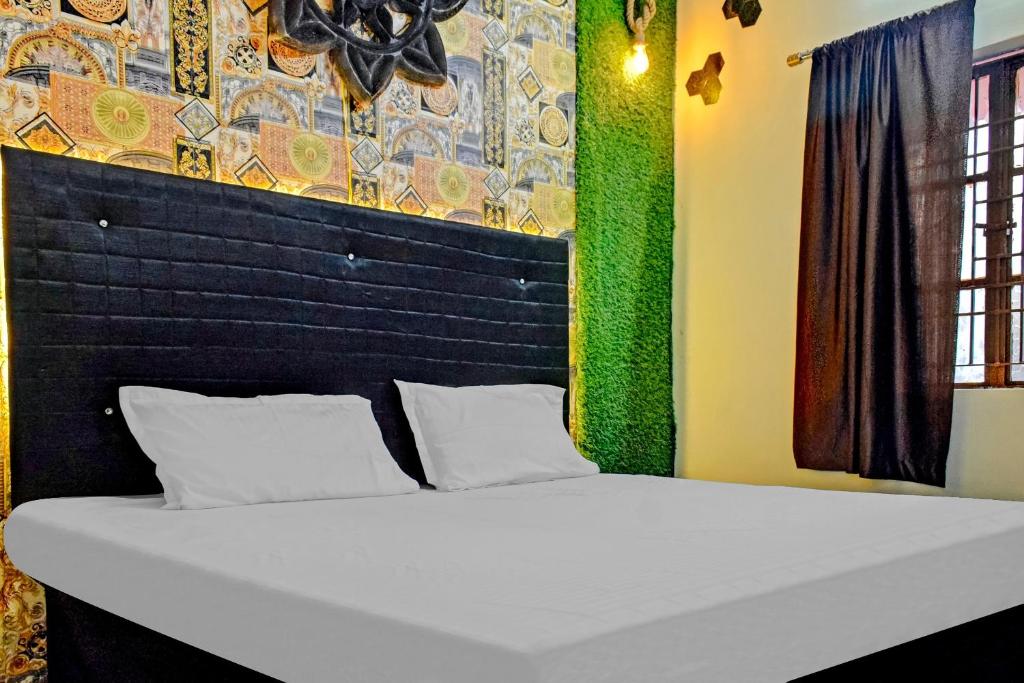 a large white bed in a room with a wall at SPOT ON Hotel Seema Inn in Durg