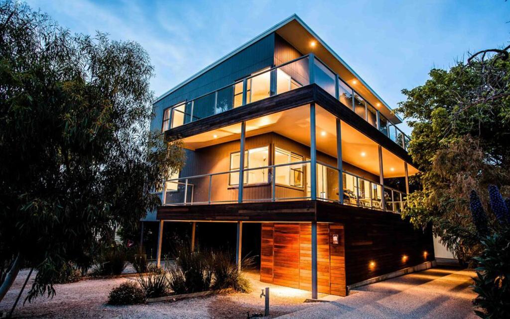 una casa grande con ventanas de cristal en un lateral. en Point Lonsdale Holiday Apartments, en Queenscliff