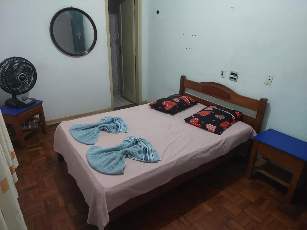a bedroom with a bed with two towels on it at Hotel Flamingo in Santos