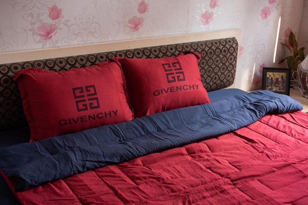 a bed with red and blue pillows on it at Small Room Close to TSN Airport Everspring house in Ho Chi Minh City