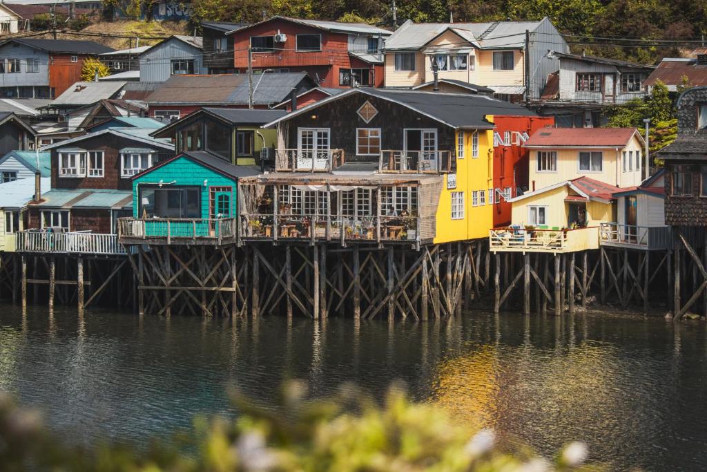 grupa domów w doku obok wody w obiekcie Palafito Hostel Chiloé w mieście Castro