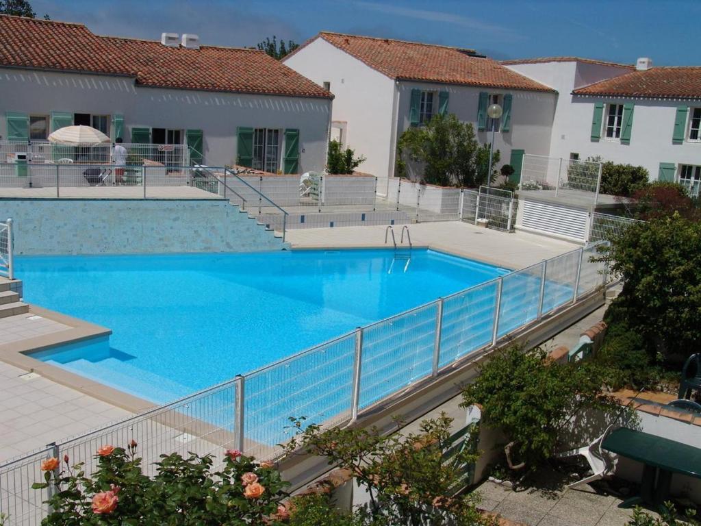 una gran piscina con una valla alrededor en Appartement Saint-Martin-de-Ré, 2 pièces, 4 personnes - FR-1-544-26, en Saint-Martin-de-Ré