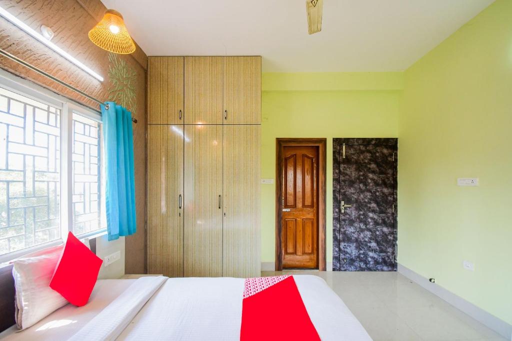 Schlafzimmer mit einem Bett mit einer roten und weißen Decke in der Unterkunft Flagship Sunshine Stay in Bhubaneshwar