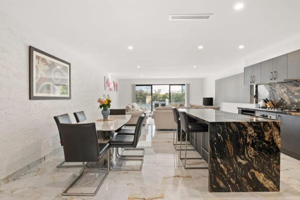 een keuken met een tafel en stoelen en een eetkamer bij CASSA CHEVRON ISLAND- Luxury Waterfront House in Gold Coast