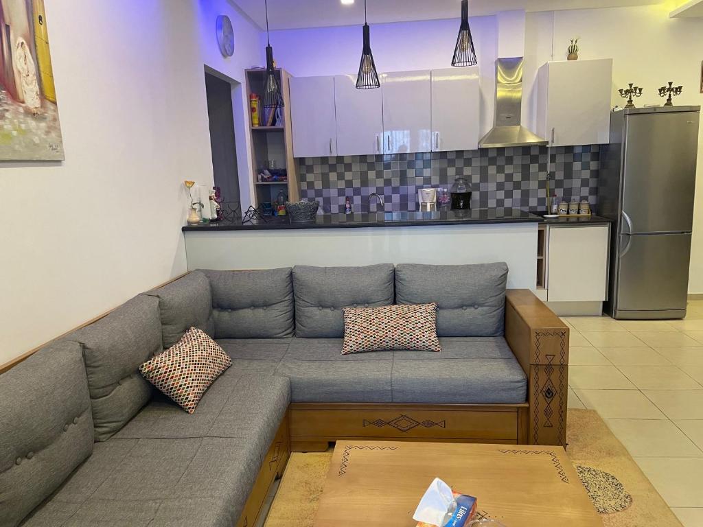 ein Wohnzimmer mit einem Sofa und einer Küche in der Unterkunft Appartement moderne, vue mer in Harqalah